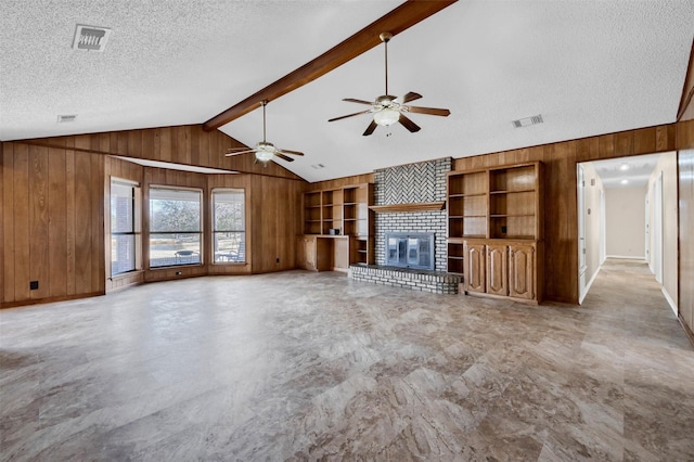 268 Roland Rd, Whitesboro, TX 76273 - unfurnished living room featuring built in shelves, a fireplace, lofted ceiling with beams, wood walls, and a textured ceiling