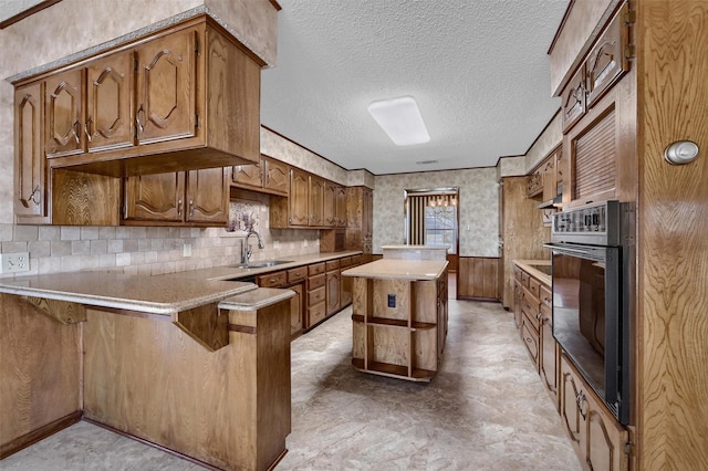 268 Roland Rd, Whitesboro, TX 76273 - kitchen featuring wainscoting, oven, a peninsula, a textured ceiling, and open shelves