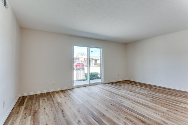 empty room with light wood-style floors and baseboards