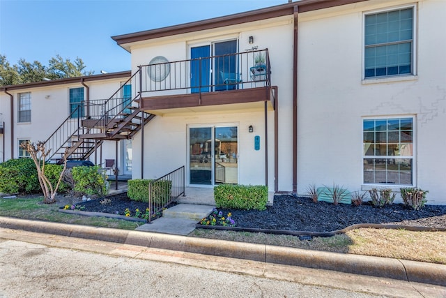 townhome / multi-family property with stairs and a balcony