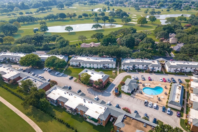 drone / aerial view with a water view, view of golf course, and a residential view