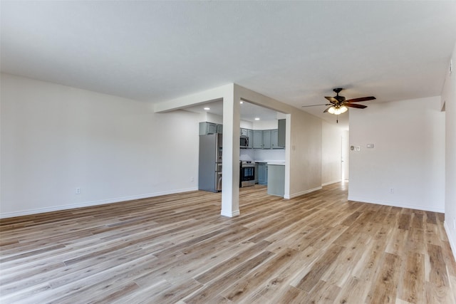 unfurnished living room with ceiling fan, light wood-style flooring, and baseboards