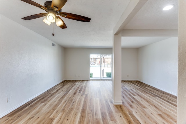 empty room featuring light wood finished floors, visible vents, a ceiling fan, a textured ceiling, and baseboards