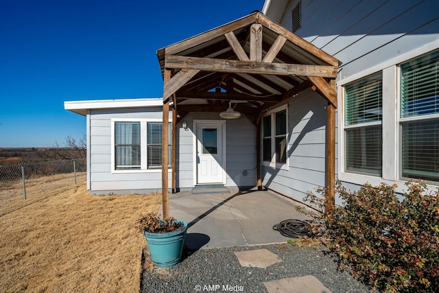 property entrance with fence and a patio