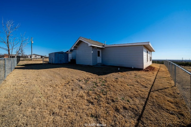 view of side of property with an outbuilding, a shed, and a fenced backyard