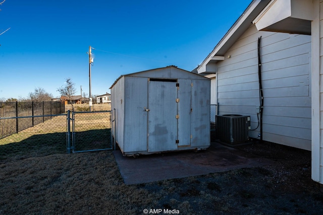 view of shed with cooling unit, a gate, and fence