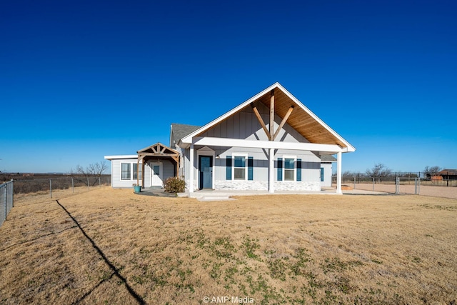 view of front of house with fence, a front lawn, and board and batten siding