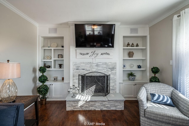 living area with a fireplace with raised hearth, ornamental molding, wood finished floors, and built in features