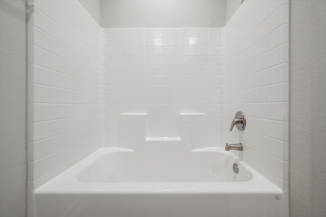 full bath featuring shower / bath combination and a textured wall