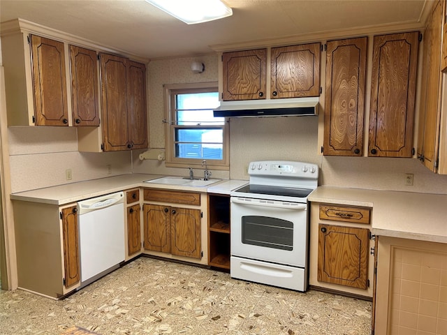 kitchen with white appliances, brown cabinetry, light countertops, under cabinet range hood, and a sink