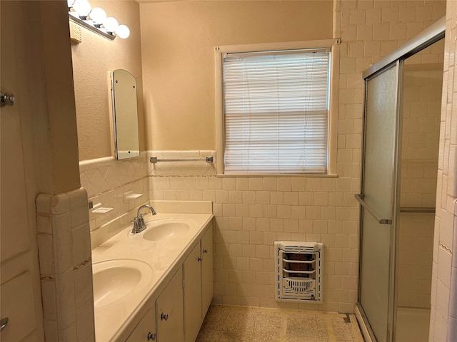 bathroom with heating unit, a stall shower, tile walls, and a sink
