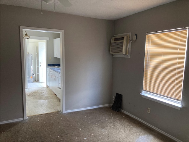 unfurnished room featuring ceiling fan, baseboards, and an AC wall unit