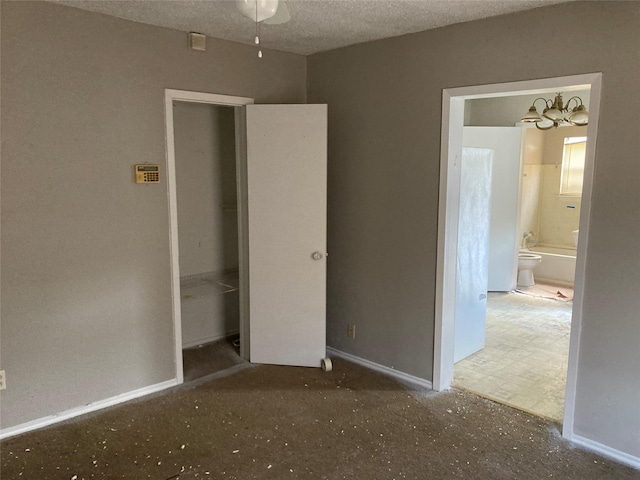 unfurnished bedroom with baseboards, a textured ceiling, and ensuite bathroom