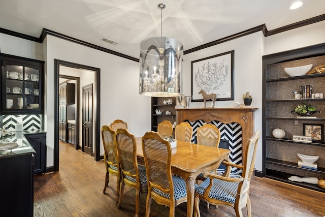 dining space with visible vents, crown molding, baseboards, and wood finished floors