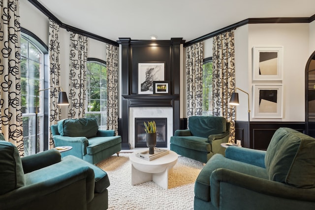 sitting room featuring a wainscoted wall, a decorative wall, a high end fireplace, and crown molding