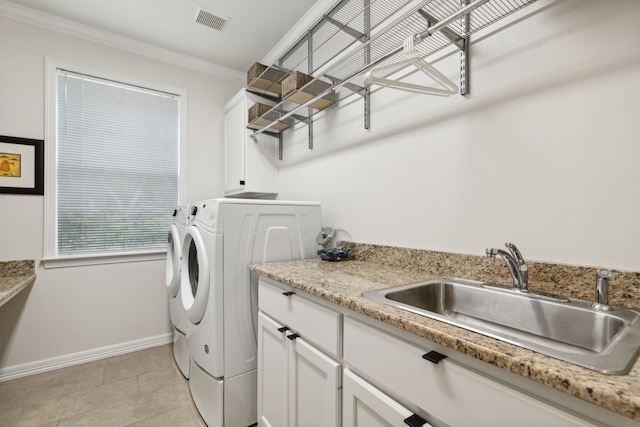 laundry room featuring cabinet space, visible vents, ornamental molding, washing machine and dryer, and a sink