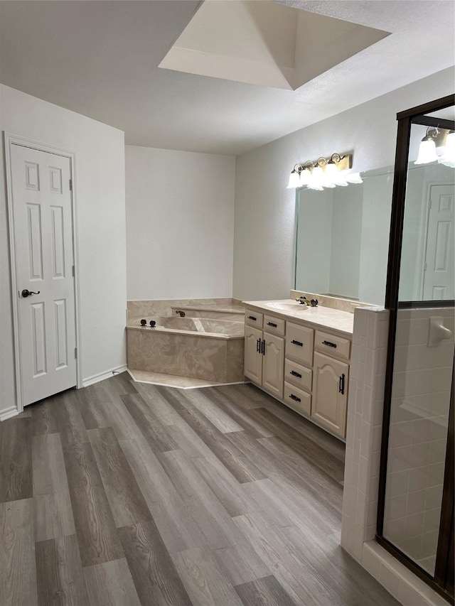 full bathroom featuring wood finished floors, vanity, a shower stall, and a bath