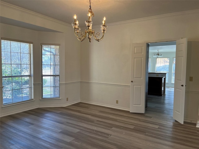 spare room with dark wood-style floors, crown molding, baseboards, and an inviting chandelier