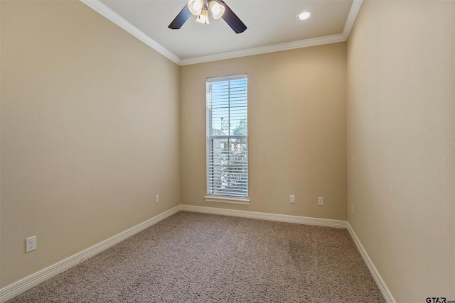 carpeted spare room with ornamental molding, baseboards, and a ceiling fan