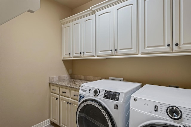 laundry room with washing machine and dryer, cabinet space, and baseboards