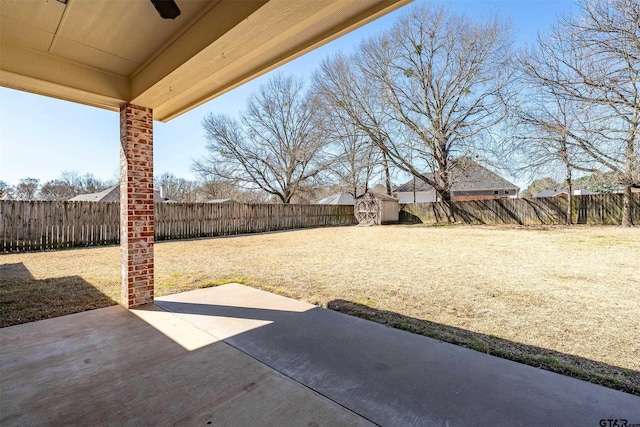 view of patio featuring an outbuilding, a storage unit, and a fenced backyard