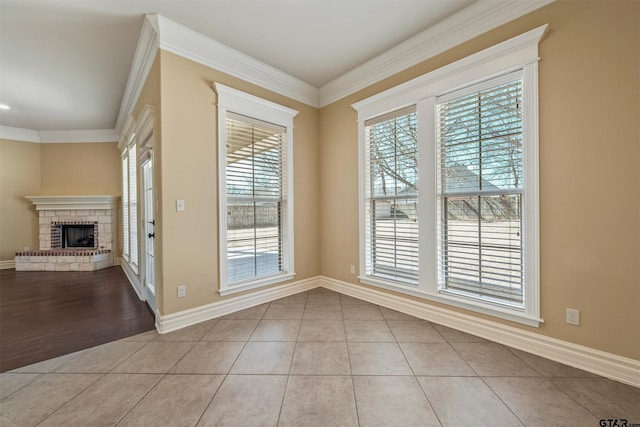 interior space featuring ornamental molding, tile patterned flooring, a fireplace, and baseboards