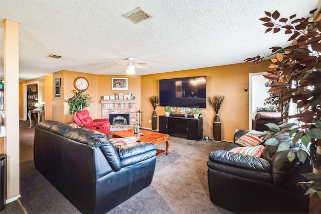 living area featuring visible vents, a ceiling fan, a brick fireplace, carpet flooring, and a textured ceiling