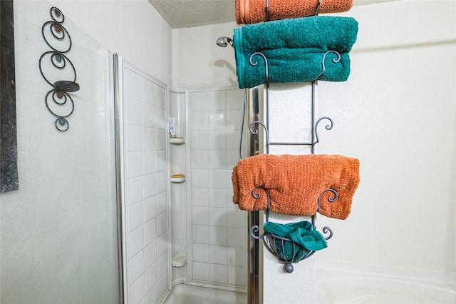 full bathroom with a textured ceiling and a shower stall