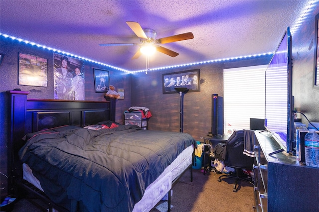 carpeted bedroom featuring a textured wall, a textured ceiling, and ceiling fan