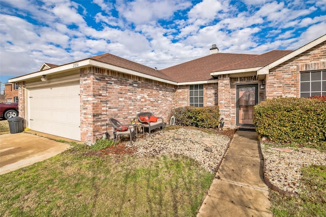 view of front of home featuring a garage, a chimney, brick siding, and a shingled roof