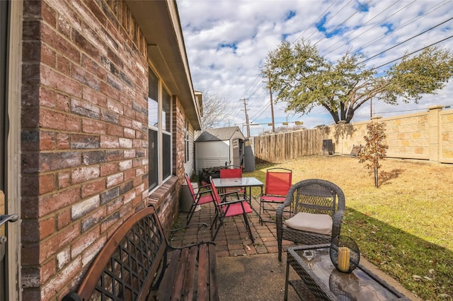 view of patio with a storage unit, an outdoor structure, and a fenced backyard