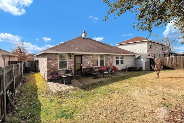 rear view of property featuring a patio, a fenced backyard, an outbuilding, a storage unit, and a yard