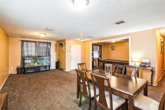 carpeted dining room featuring baseboards, visible vents, and a textured ceiling