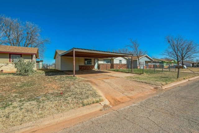 ranch-style house with brick siding, fence, driveway, a carport, and a front yard