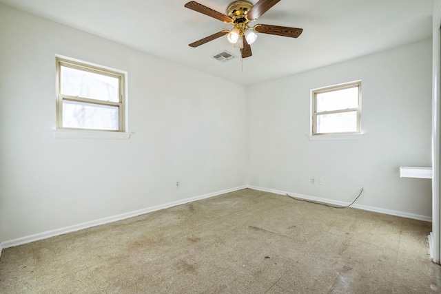 empty room with ceiling fan, visible vents, and baseboards