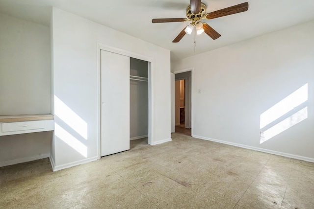 unfurnished bedroom with ceiling fan, baseboards, a closet, and built in study area