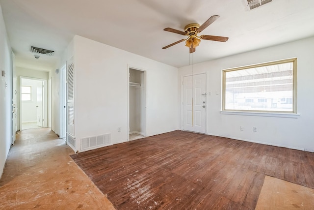 empty room featuring hardwood / wood-style flooring, ceiling fan, and visible vents