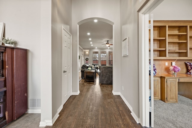 hall with arched walkways, visible vents, baseboards, and recessed lighting