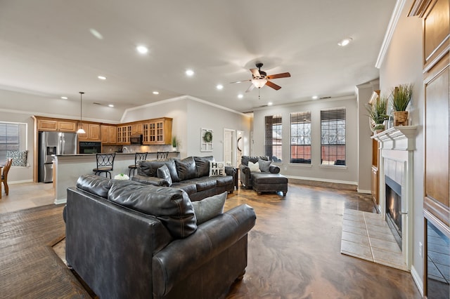 living area with a tile fireplace, baseboards, and recessed lighting