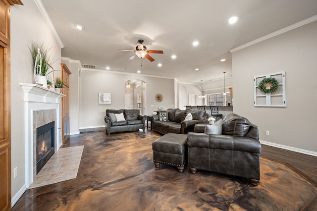 living area featuring arched walkways, visible vents, a tiled fireplace, and recessed lighting