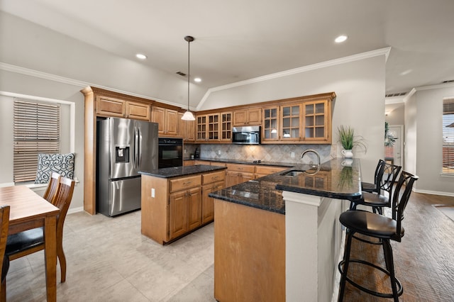 kitchen with appliances with stainless steel finishes, brown cabinetry, and a sink