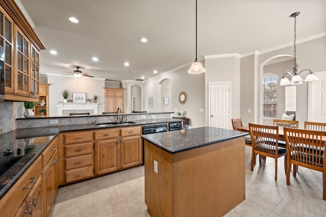 kitchen featuring a peninsula, backsplash, a sink, and a center island