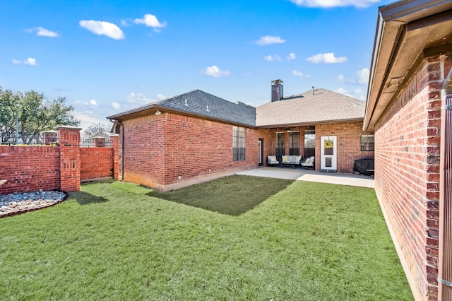 back of house featuring an outdoor hangout area, brick siding, fence, a lawn, and a patio area