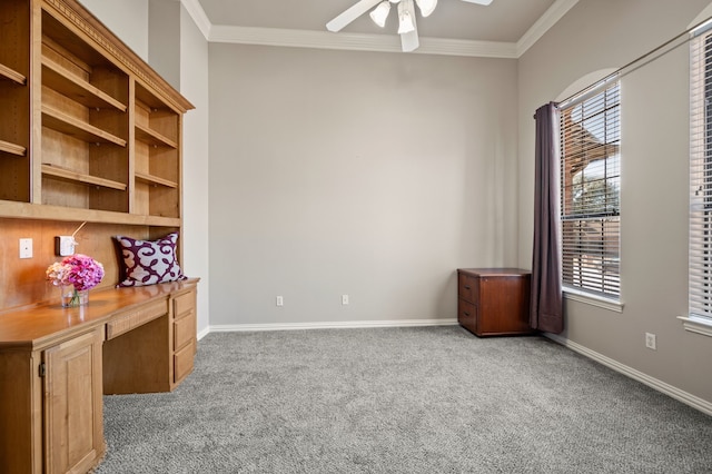 unfurnished office with carpet flooring, crown molding, built in desk, and baseboards