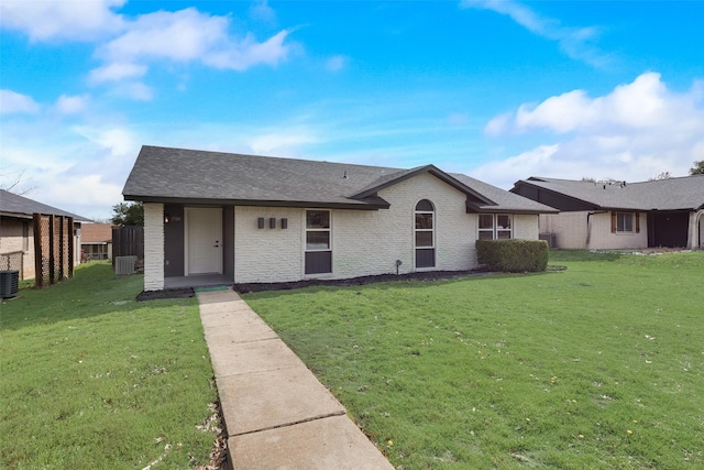 single story home with a shingled roof, brick siding, a front lawn, and central AC unit