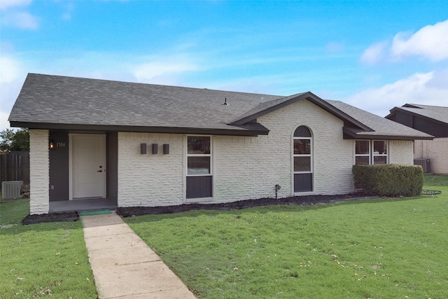 ranch-style home with a shingled roof, a front lawn, brick siding, and central air condition unit