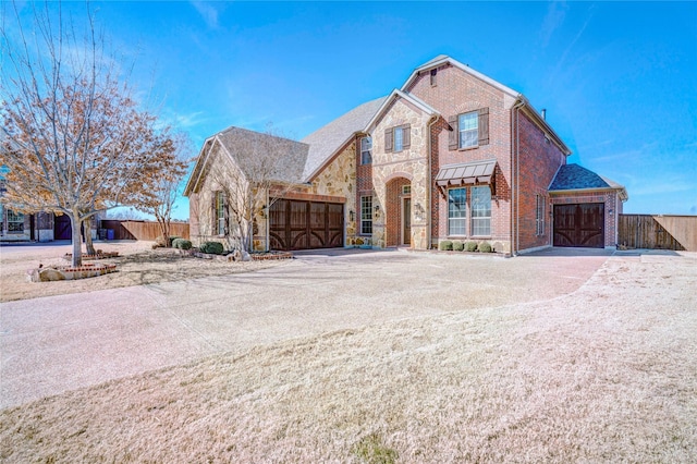 view of front of home with stone siding, brick siding, and fence