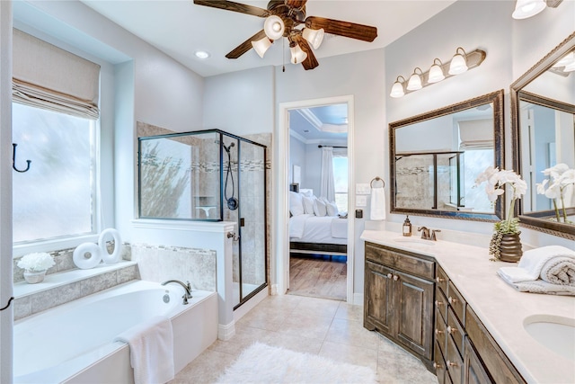 ensuite bathroom featuring a sink, a bath, tile patterned floors, double vanity, and a stall shower