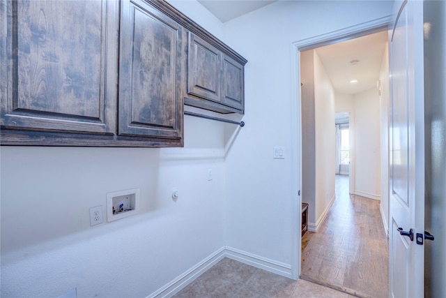 washroom with cabinet space, baseboards, and washer hookup