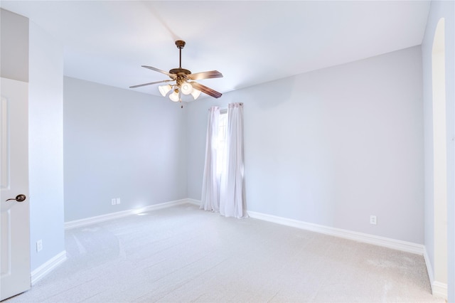 unfurnished room with baseboards, a ceiling fan, and light colored carpet